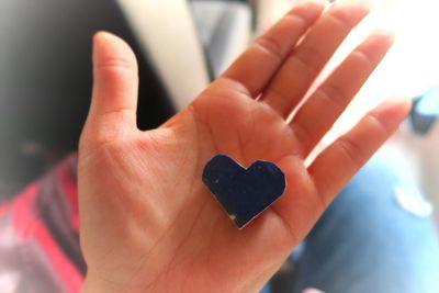 Cropped image of woman holding heart shape decoration