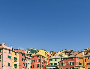 Low angle view of buildings against clear blue sky