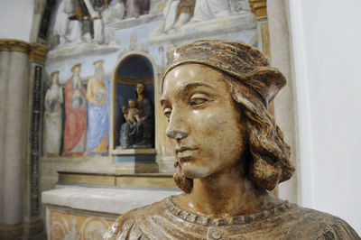 Bust of raffaello sanzio, known as raphael. on the background a fresco painted by raffaello.