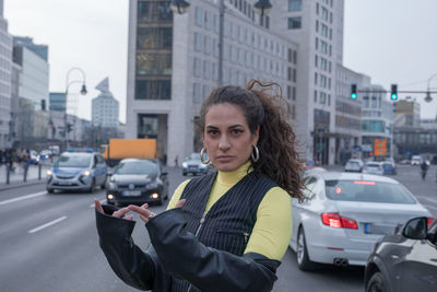 Portrait of young woman gesturing in city