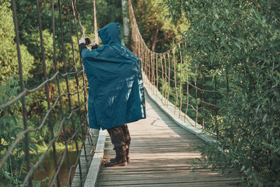 Rear view of woman walking on footpath in forest