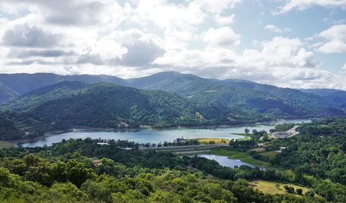 Scenic view of river and mountains against sky