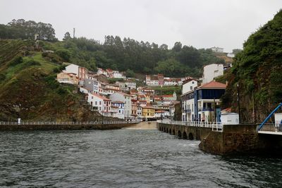 River amidst buildings in city against sky