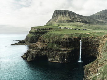 Scenic view of rock formation in sea against sky