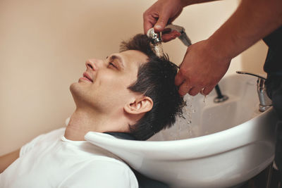 Side view of man washing hands