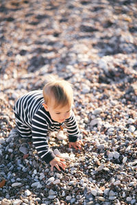 High angle view of boy on pebbles