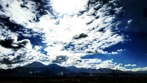 Scenic view of mountains against cloudy sky