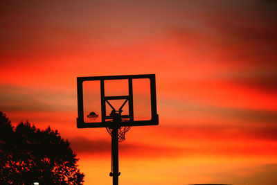 Low angle view of basketball hoop against sky during sunset