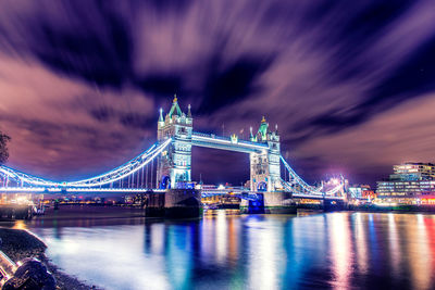 Illuminated bridge over river at night
