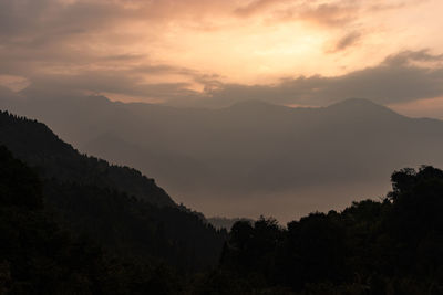 Scenic view of silhouette mountains against sky at sunset