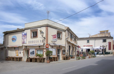 Buildings by street against sky in city