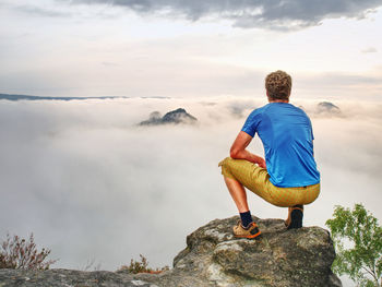 Person on a top of mountains in a misty cloud. sunrise view. tourist people enjoy a moment in nature