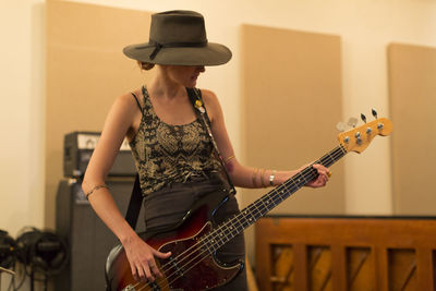 Young female musician playing a bass guitar