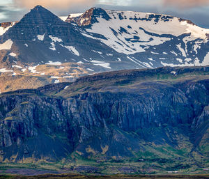 Rugged mountain range dominates the dramatic scenery during a brief icelandic summer