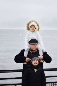 Father with daughter and son against sea and sky