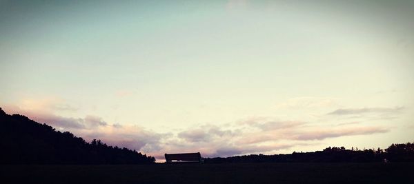 Silhouette landscape against sky at dusk