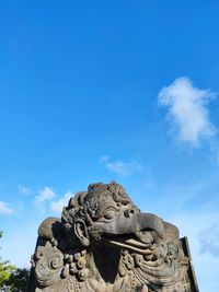 Low angle view of statue against blue sky