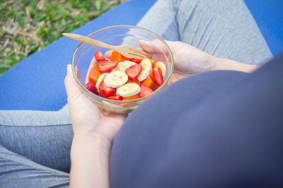 Low section of woman holding fruits