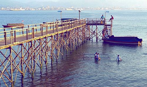 People in sea against sky