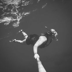 Woman holding monopod while swimming in sea