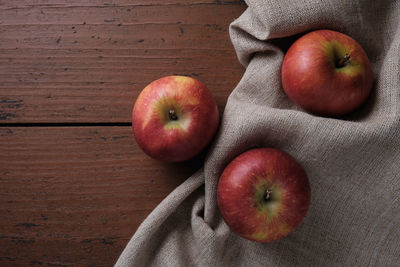 Fruits in a linen tablecloth on a old wooden table. apple harvest theme. place for text, top view