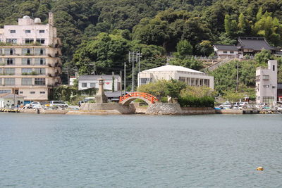 Arch bridge over river amidst buildings in city