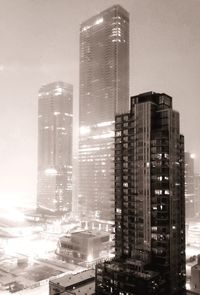 Modern buildings in city against sky at night