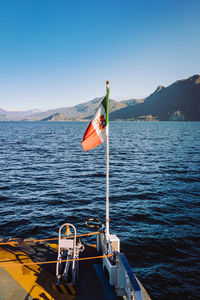 Close-up of flag on tourist boat as it crosses lake maggiore