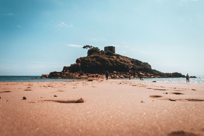 Rocks on beach against sky