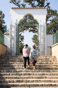 Rear view of couple walking on staircase