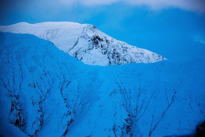 Scenic view of snowcapped mountain against blue sky