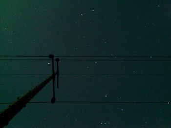 Electricity pylon against sky at night