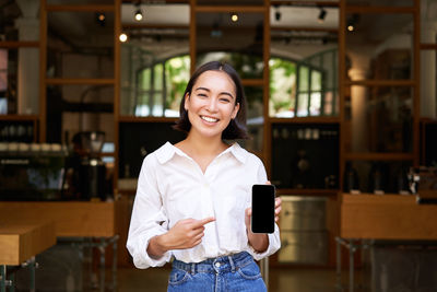 Portrait of young woman standing in store