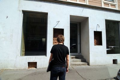 Rear view of woman standing against building