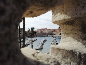 Boats moored in sea by city against sky