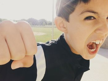 Portrait of boy showing fist while shouting