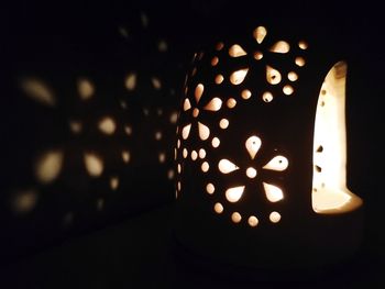 Close-up of illuminated candles in darkroom