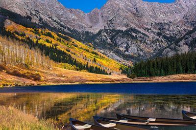 Boats moored on lake against mountains in autumn