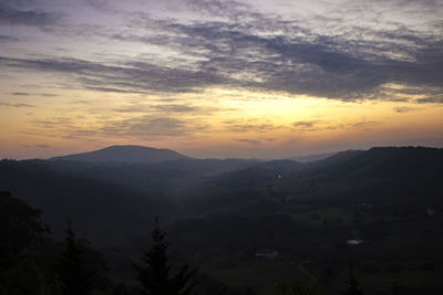 Scenic view of silhouette mountains against sky at sunset