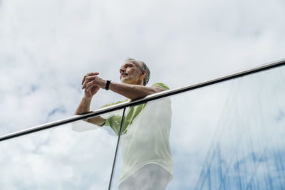 Thoughtful man leaning on glass railing