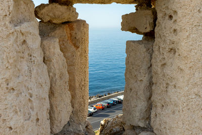 Rock formations by sea against sky