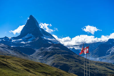 Scenic view of snowcapped mountains against blue sky