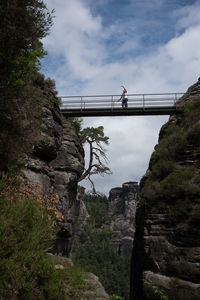 Man and woman on bridge against sky