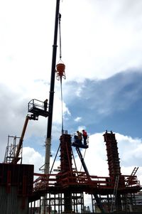 Low angle view of crane against sky