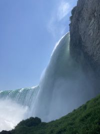 Scenic view of waterfall against sky