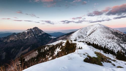 Scenic view of snow covered mountains against sky during sunset