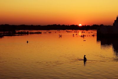 Silhouette people in the river, sunset in u bein bridge, mandalay, myanmar