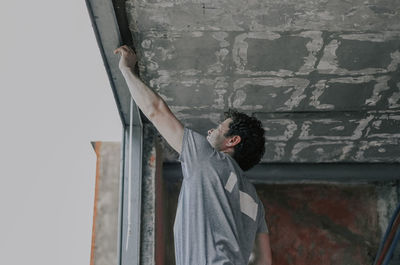 Caucasian male builder clean the window opening.
