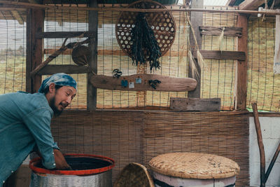 Man standing by basket in shed