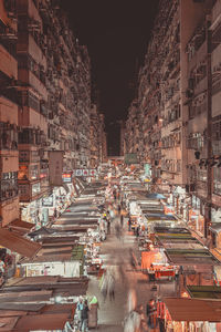 High angle view of people on street amidst buildings at night